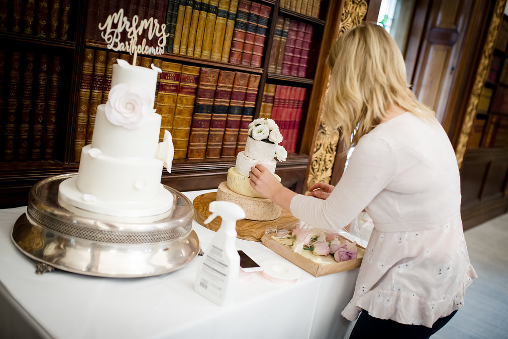 florist decorating wedding cheese cake with fresh flowers