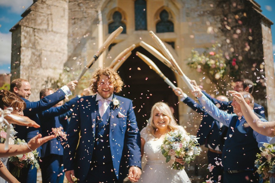 cricket bat guard of honour with confetti in front of church