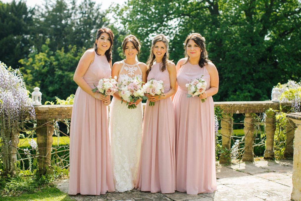 bridesmaids in long pale pink dresses with pink and ivory bouquets