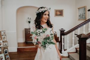 bride in white dress with floral crown and bouquet