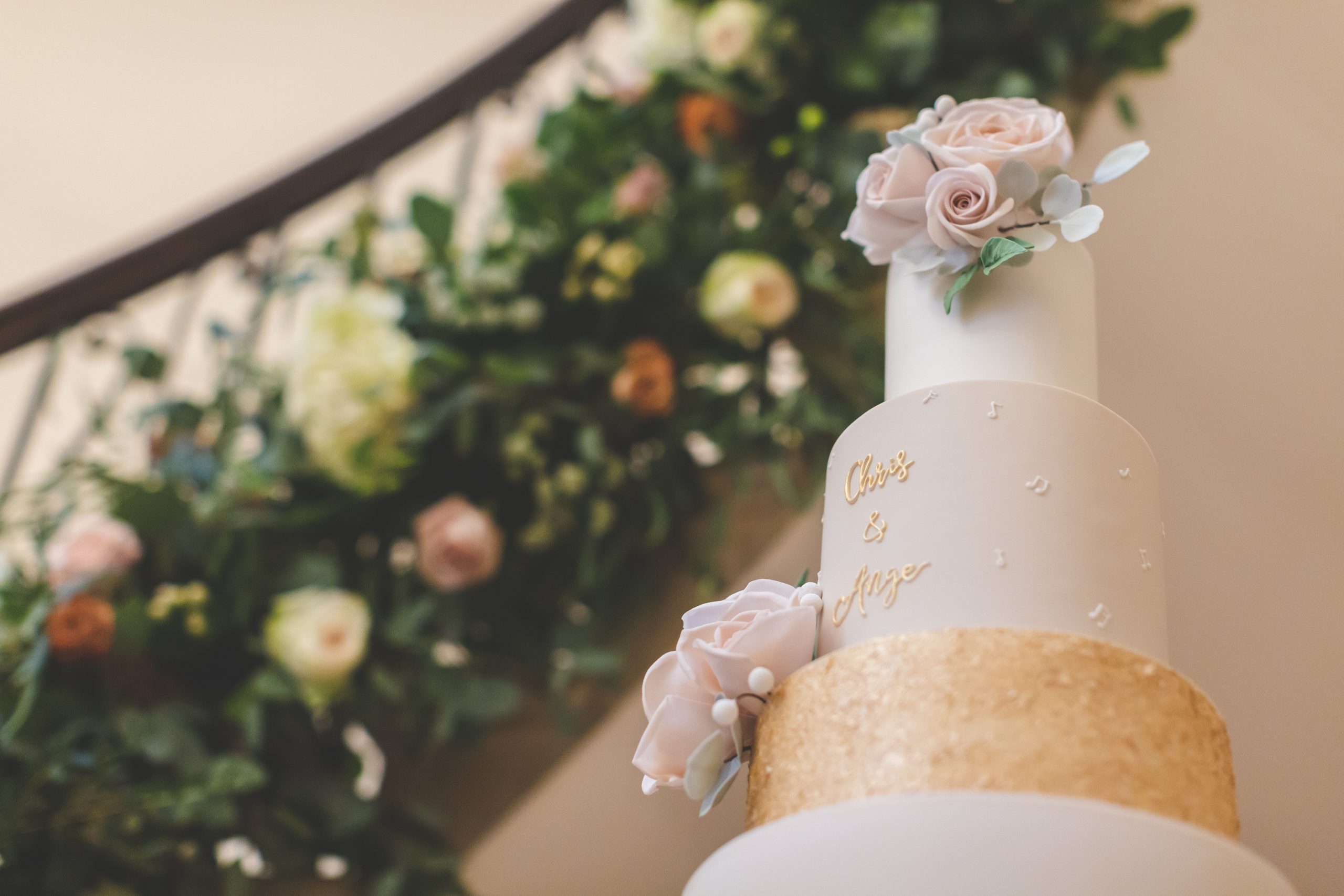 wedding cake against floral staircase garland at eastington park