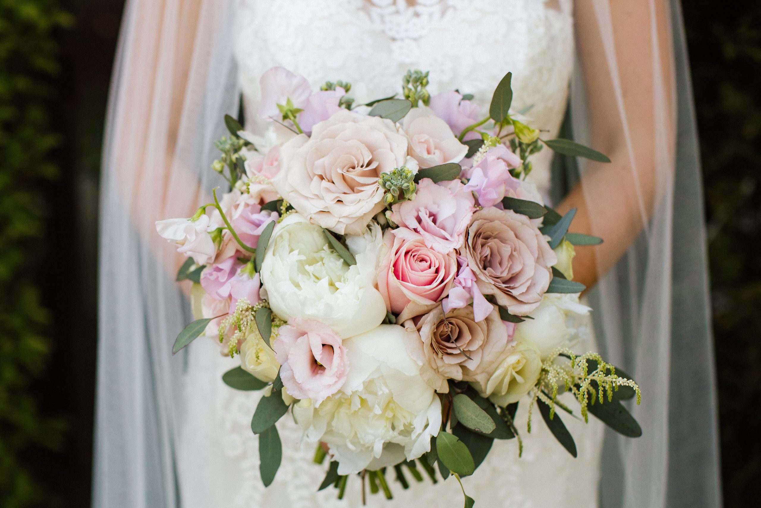 bride holding handtied wedding bouquet with pink and ivory flowers