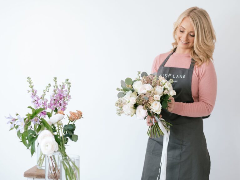 cost of wedding flowers florist in apron making bouquet