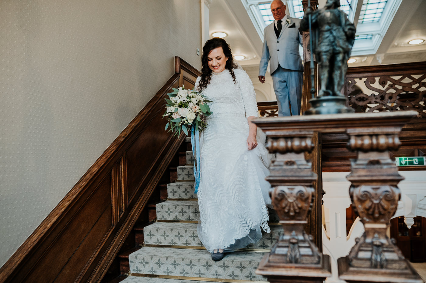 bride descending staircase with wedding bouquet at Clevedon Hall North Somerset wedding venue