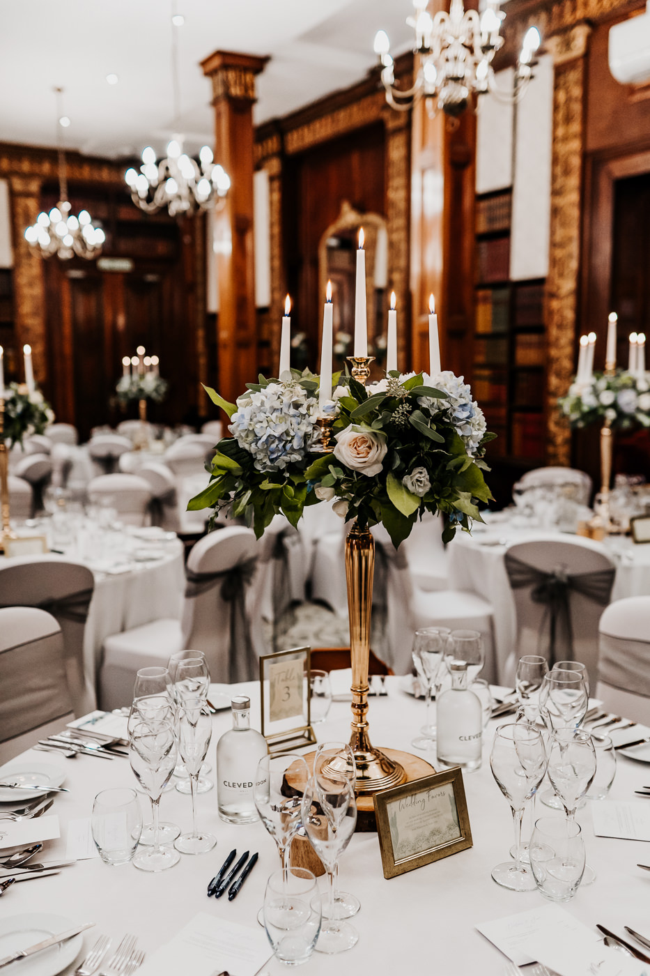 wedding breakfast reception floral arrangements on tall gold candelabras 