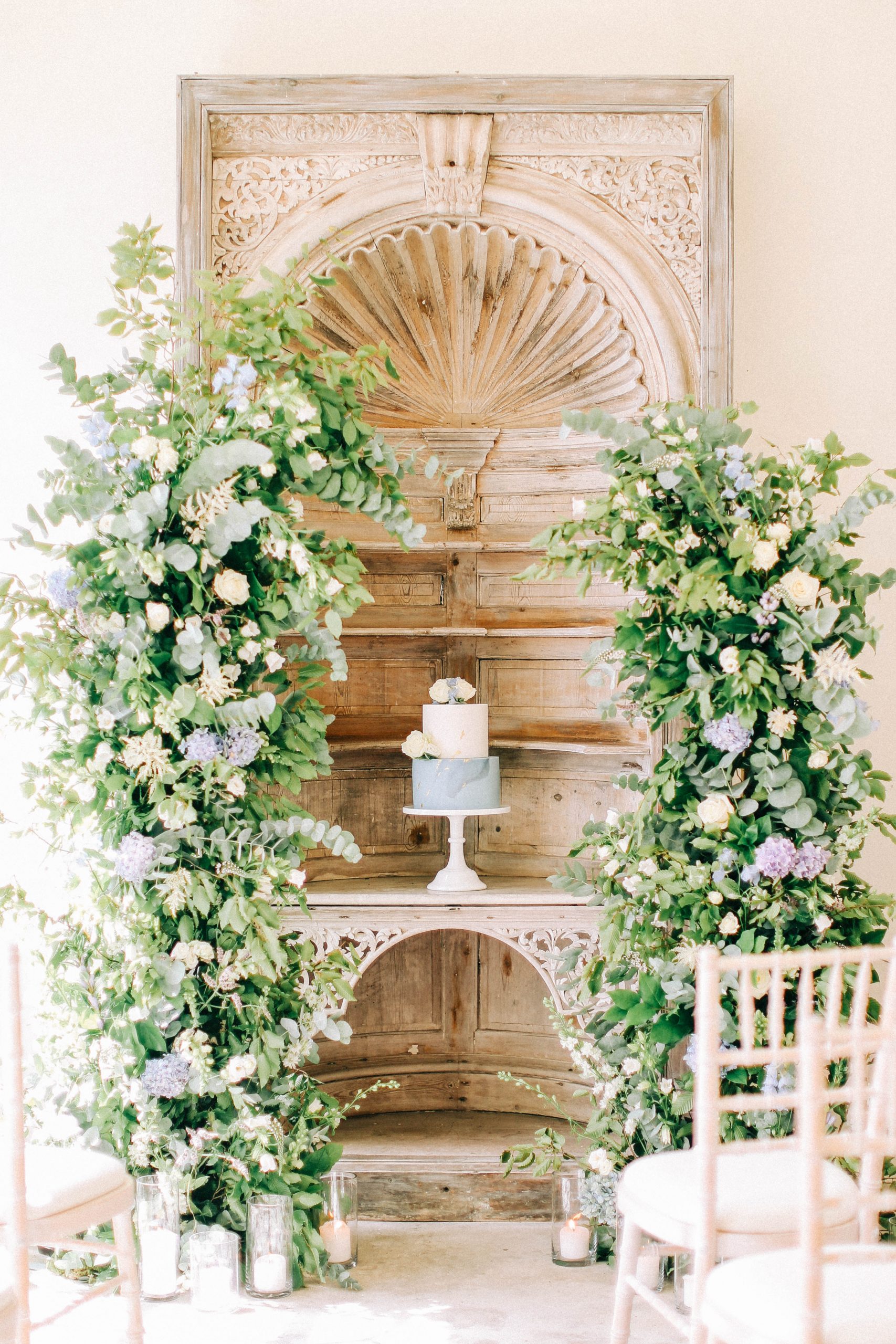 Wedding cake framed by floral installation floral arch