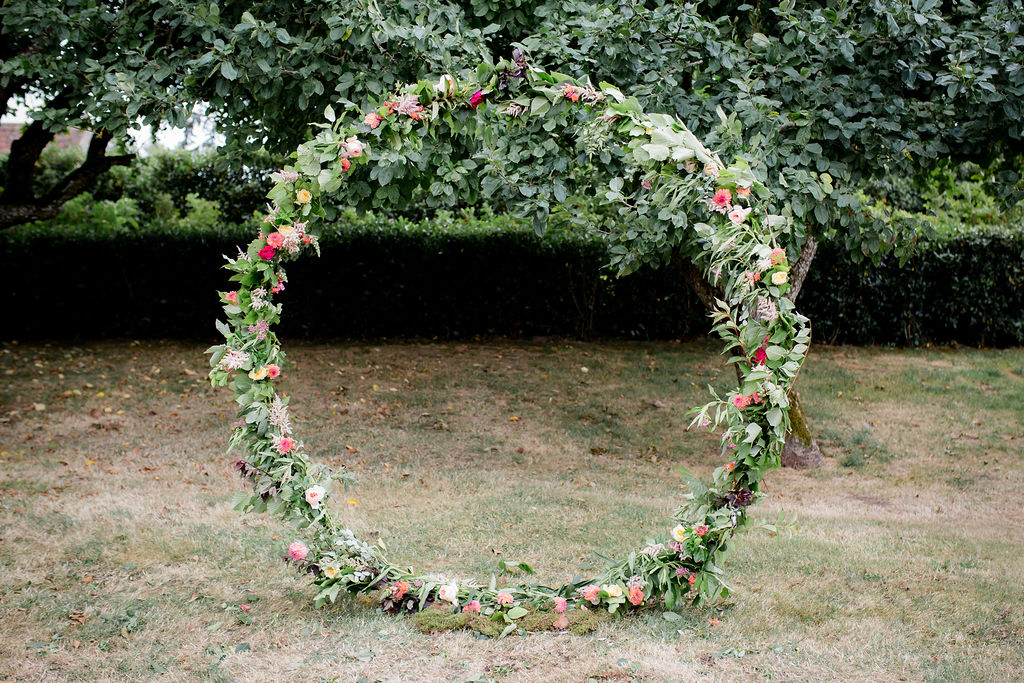 Floral moon gate for outdoor wedding ceremony