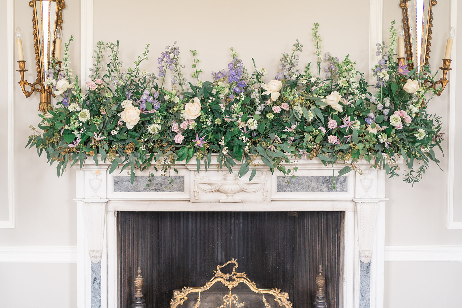 floral installation above fireplace at wedding ceremony